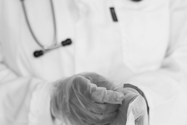 Arzt zieht Operationshandschuhe an – operative Dermatologie